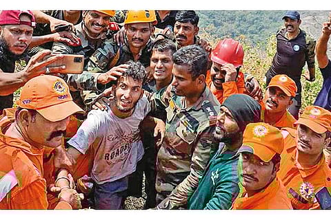 Army personnel after rescuing Babu (C), who was trapped in a steep gorge in Malampuzha mountains