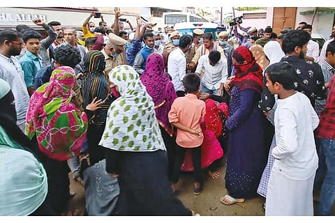 People gather in front of the houses of Abdul Khader and Mohammed Yasin in Thanjavur on Saturday