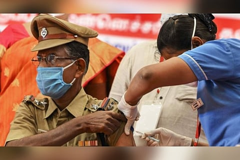 A health worker injecting a covid jab to a police personnel (Image credit: PTI)