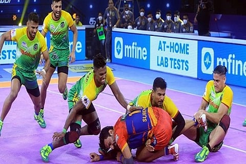 Patna Pirates defender Mohammadreza Shadloui grabs an ankle hold on U.P Yoddha raider Surender Gill