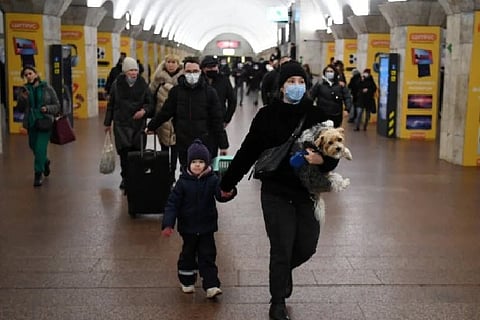 Woman with a child and dog walks at a metro station in Kyiv (AFP)