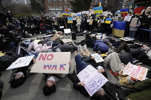 Protesters lie down on ground during a rally against Russian invasion (Image credit: AP)