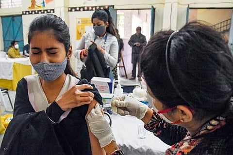 A health worker injecting a covid jab to a person