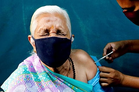 A woman reacts as she receives a dose of Covishield (Credit: Reuters)