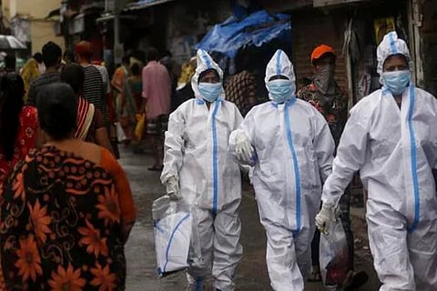 Health workers return after screening people for Covid-19 symptoms in Dharavi (Credit: AP)