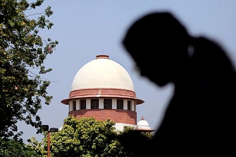 A woman checks her mobile phone inside the premises of the Supreme Court (Credit: Reuters)