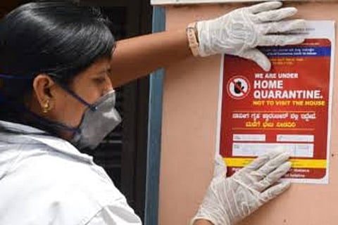 A woman reacts as a healthcare worker collects a swab sample from her (Credit: Reuters)