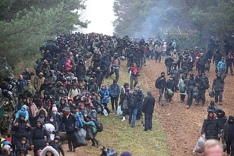 Migrants walk towards the Bruzgi-Kuznica Bialostocka border crossing (Credit: Reuters)