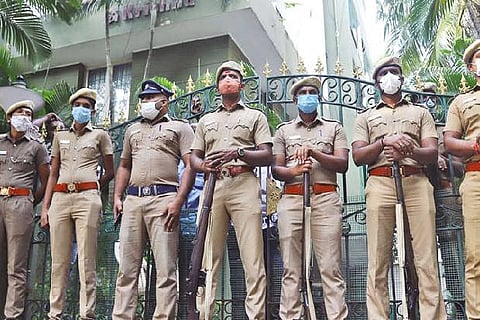Police stand outside one of the properties belonging to the ex-minister.