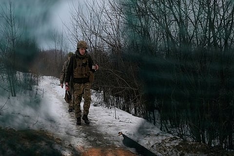 Service members of the Ukrainian armed forces walk at combat positions (Photo Credit:Reuters)
