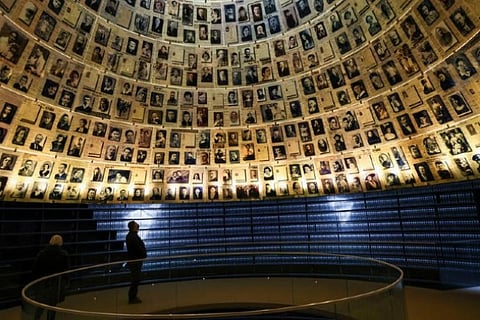 A man looks up at pictures of victims of the Holocaust ahead of International Holocaust Remembrance