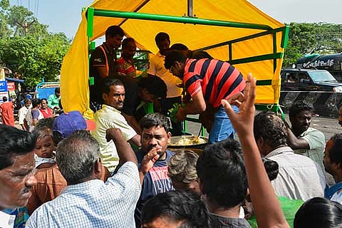Volunteers distribute food packets to residents at the Palavakkam Govt School