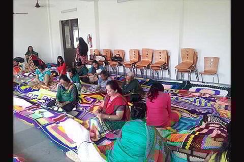 Women stitching the crochet blankets together