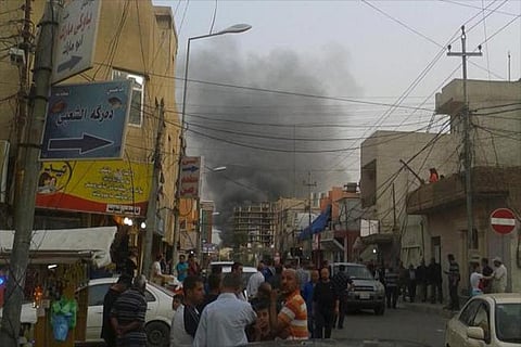 People watch the smoke rising from the site of a bomb attack 