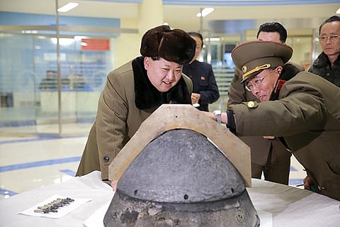 N Korea?s Kim Jong Un looks at a rocket warhead tip after a simulated test of a ballistic missile