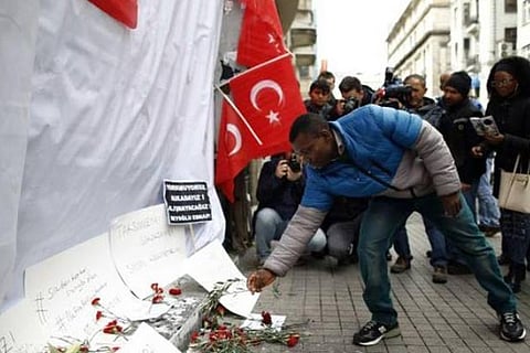 A man places an olive branch (symbol of peace) on the site of an explosion in Istanbul