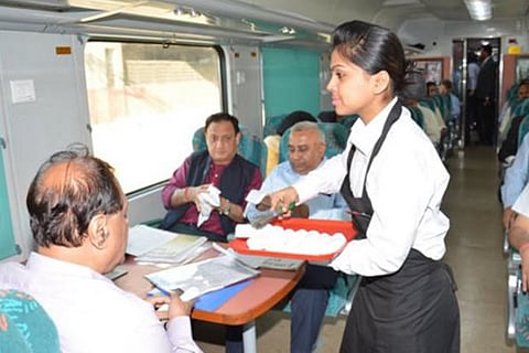 A Gatimaan Express hostess serves passengers on the inaugural journey