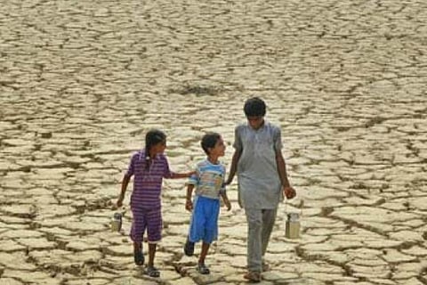 Family members take turns to fetch watch form tanks and hand pumps in the drought hit region
