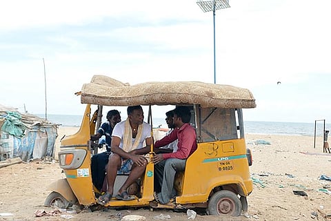 A group of men take shelter from intense heat in an abandoned auto