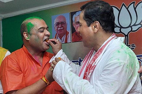 BJP CM candidate Sarbananda Sonowal exchanging sweets with party leader Himanta Biswa Sarma