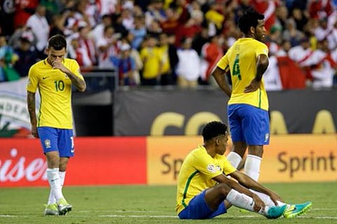 Brazil's Lucas Lima (left) and Gil (centre) stand on the pitch after a 1-0 loss to Peru