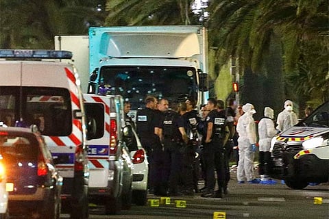 French police forces and forensic officers stand next to a truck that ran into a crowd