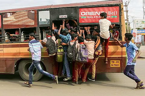 Students seen travelling on the footboard of a bus near Taramani