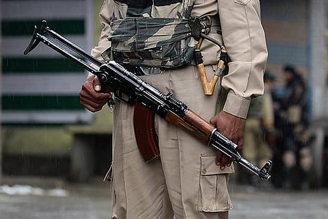 An Indian trooper holds a weapon during a curfew in Srinagar