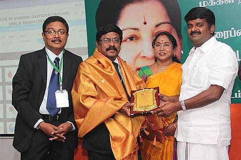 Health Minister C Vijaya Bhaskar honours a teacher at the Institute of Orthopaedics