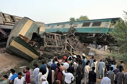 Locals look at the wreckage after two trains collided near Multan, Pakistan