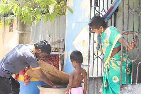 Volunteers of Care and Welfare checking the cement cisterns for mosquito breeding