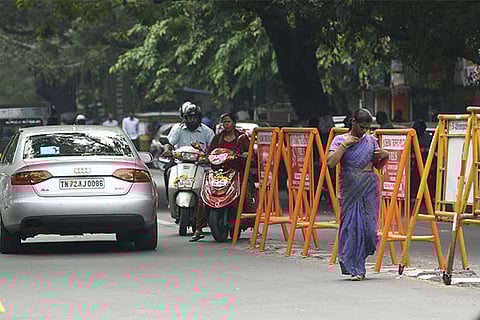Two-wheeler riders and auto drivers manoeuvre around barricades and try to go under the flyover