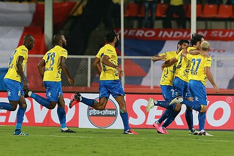 Kerala Blasters players run towards Cedric Hengbart, who scored the first goal against Pune City