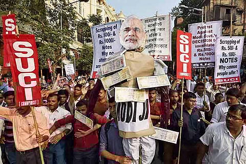 Members of SUCI carry an effigy of PM Modi during a protest against the demonetisation