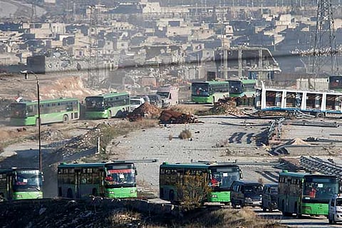 Ambulances and buses evacuating people drive out of a rebel-held part of Aleppo, Syria