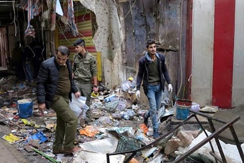 Iraqi security forces gather at the site of a bomb attack at a market in central Baghdad