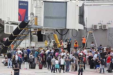 People wait on the tarmac of Fort Lauderdale-Hollywood International airport after the shooting