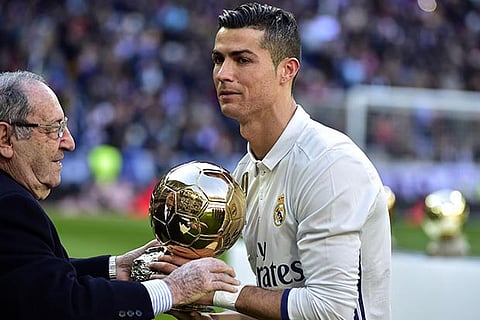 Former Spanish player Francisco Gento (left) hands over the Ballon d?Or to Ronaldo