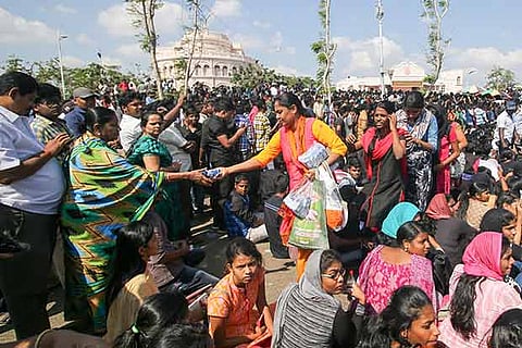 A volunteer hands out food items to protesters on the Marina