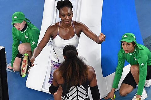 Venus Williams (in white) rushes to congratulate Serena Williams