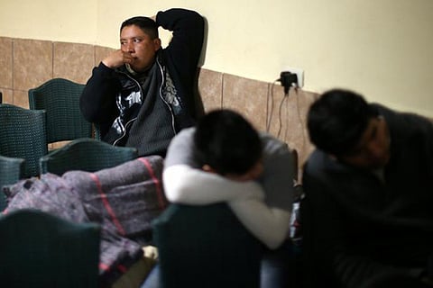 Migrants sit in the chapel at the Juan Bosco migrant shelter after being deported from the US