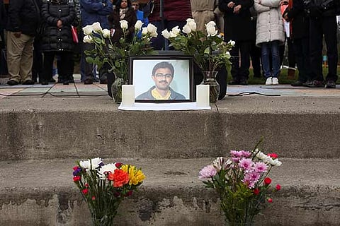 A picture of Srinivas Kuchibotla is surrounded by flowers during a vigil