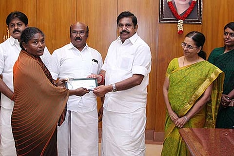 CM Palanisamy distributing financial relief to a fisherwoman, who lost her boat to SL Navy