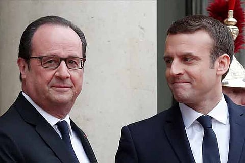Outgoing French President Francois Hollande greets President-elect Emmanuel Macron