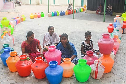 Residents with plastic pots waiting for water to be supplied by the government in RK Nagar