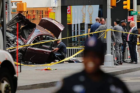 Police officers secure the area near a car after it plunged into pedestrians in Times Square