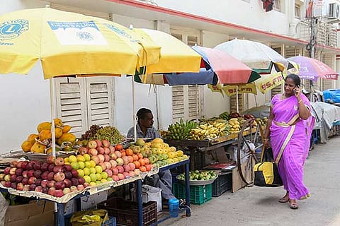 A fruit vendor waits for customers on the side of a road in Mylapore on Friday