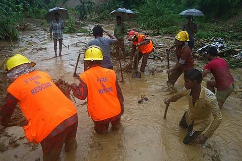 Bangladeshi fire fighters and residents search for bodies after a landslide in Bandarban