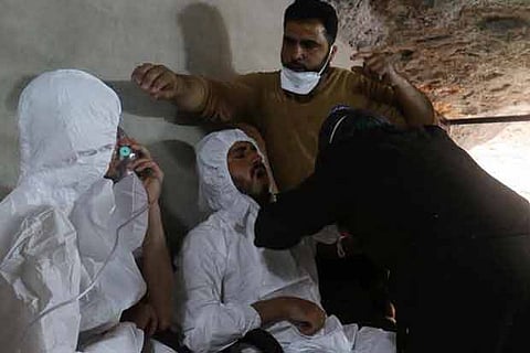 File photo of A man breathes through an oxygen mask as another one receives treatments in Syria.