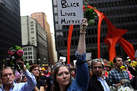 People hold flowers at a vigil in Chicago, Illinoid